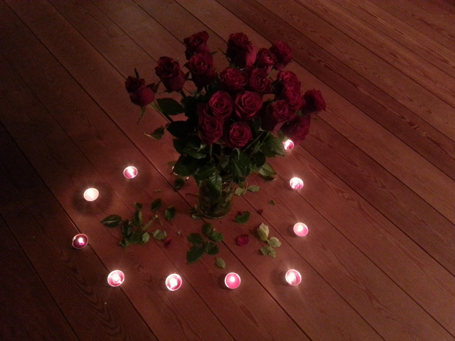 rote Rosen und rundherum Kerzen