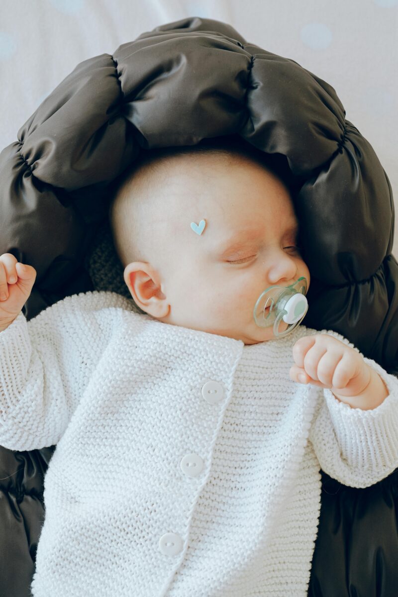Schlafendes Neugeborenes in warmem Strampler – Babyschlafsack und Schlafkleidung