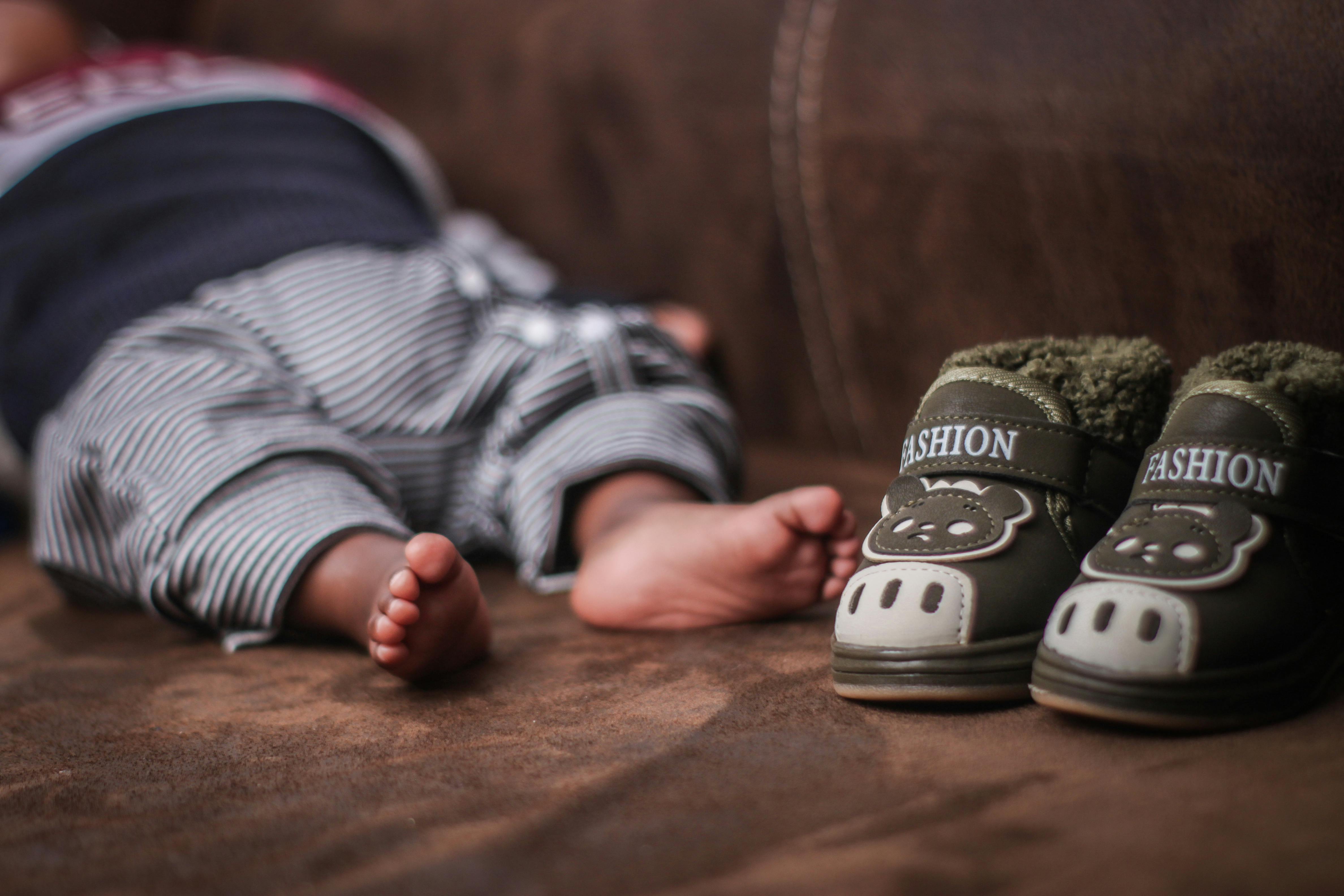 Kleine Babyfüße in bunten Lauflernschuhen – natürliche Barfußschuhe für erste Schritte