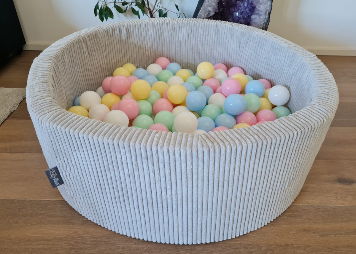 KiddyMoon Baellebad hellgrau mit bunten Pastellbaellen auf Holzboden